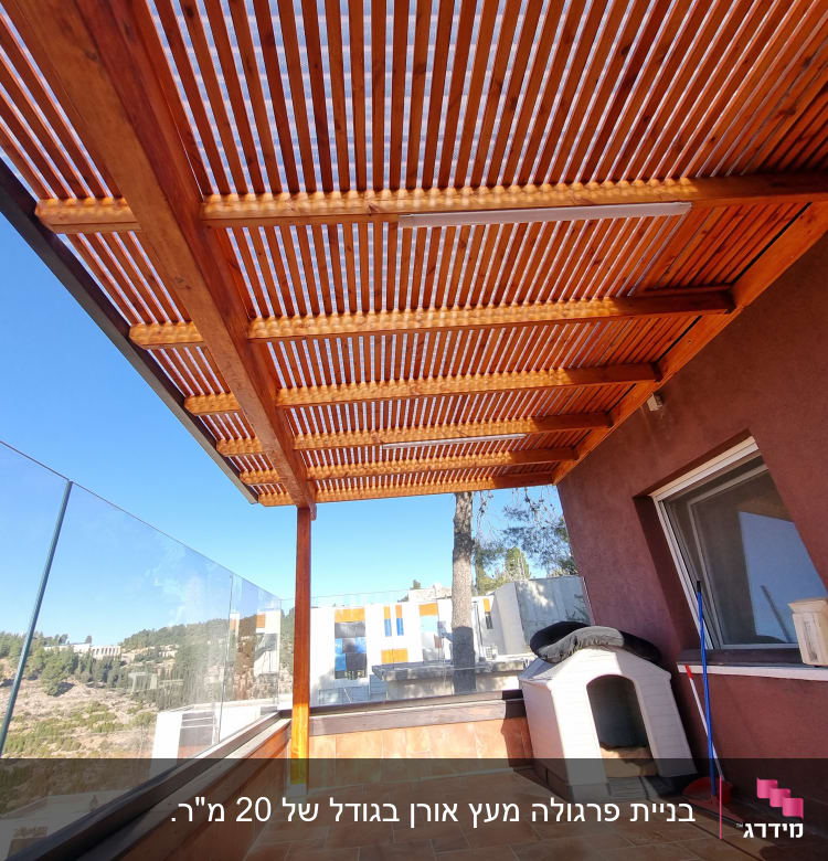 פרגולה מעץ עם גג לוחות עץ על מרפסת